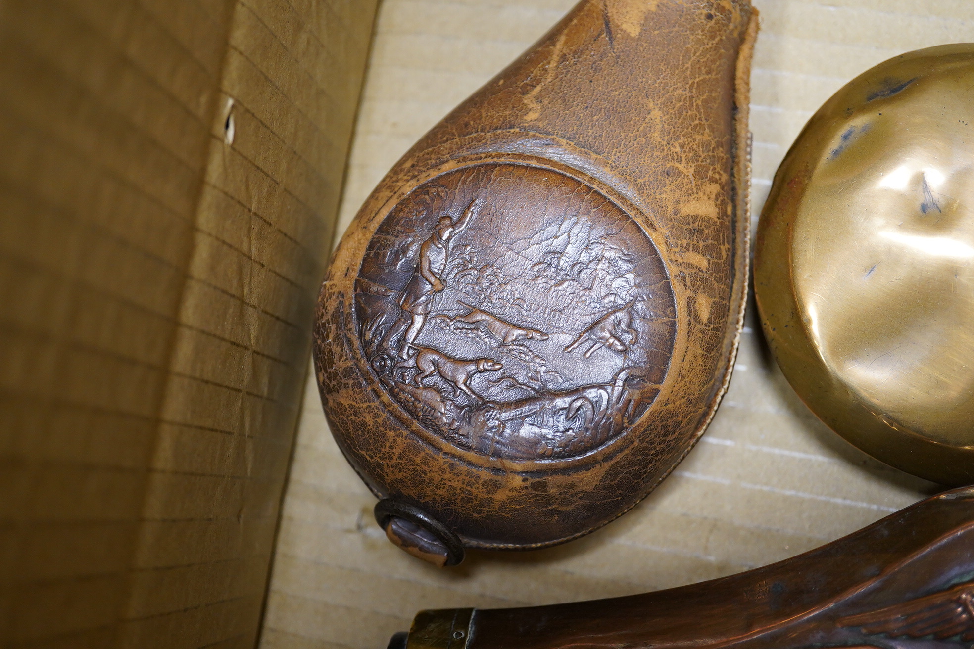 Four assorted copper powder flasks comprising; a three-way flask by Sykes (dented), ‘three horses head’ flask by Hawksley and two others, together with two leather shot flasks, a horn powder flask and a percussion nipple